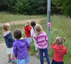 several children are standing near a street sign