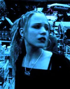 a woman with dreadlocks is standing in front of a store display and looking at the camera