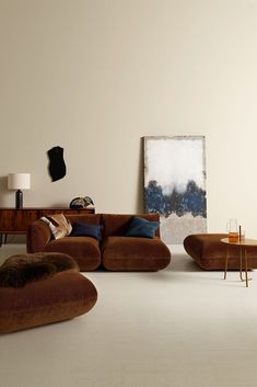 a living room filled with furniture and a large painting hanging on the wall above it