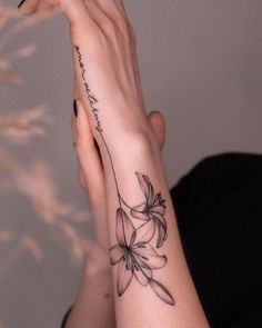 a woman's arm with a flower tattoo on the left side of her hand