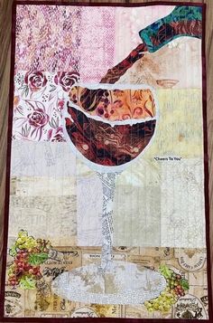 a quilted wall hanging with a glass of wine on it