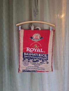 a red and white bag hanging from a wooden hanger on a wall with other items in the background