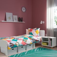 a bedroom with pink walls, white furniture and colorful rugs on the hardwood floor