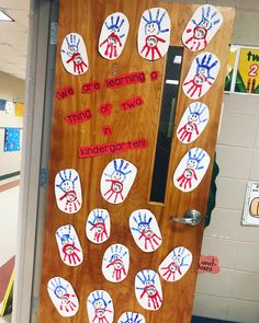 a door decorated with handprints and the words we are learning a thing of two