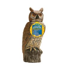 an owl figurine sitting on top of a tree stump