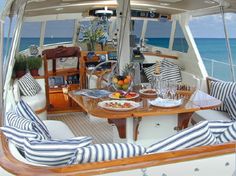 the interior of a sailboat with two seats and a table on it, overlooking the ocean