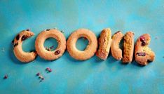 the word cookie spelled out in doughnuts on a blue surface