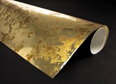 a gold foiled piece of paper on a black background