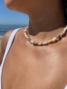 This beautiful handmade Sea shells choker is a perfect match for any outfit in any occasions.   With the adjustable strings that hangs on your back, would make a beautiful showcase and add a little flare. Choker is easy to put on since it has an adjustable 9 inches of strings on both side. Sea shells are slightly different in shape, size and color. Wax cord threads are durable even when wet.  8 mm 14k gold plated over stainless steel beads. Choker is 13- 14 inches plus 9 inches adjustable strings on both sides. Model picture shown is 14 inches. Sizes to choose are: 13 inches 14 inches 15 inches 16 inches 18 inches Model picture shown is old gold. Thread colors to choose are: 1. Old gold 2. Brown 3. Black 4. Blue 5. Cream 6. White This choker is handcrafted by me and it comes in a beautiful Bohemian Handmade Choker For Beach, Handmade Strand Choker For Vacation, Hippie Choker Jewelry For The Beach, Bohemian Strand Choker For Festivals, Hippie Beach Choker Necklace, Handmade Strand Choker For Festivals, Bohemian Handmade Strand Choker, Adjustable Macrame Beaded Necklaces For The Beach, Yellow Beaded Necklace For Beach