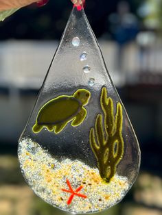 a glass ornament with sea animals and plants in the water on it's side