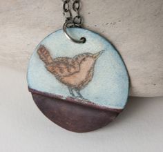 a necklace with a bird painted on it