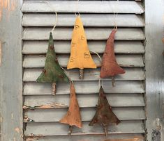 four different colored wooden ornaments hanging on a metal doorknobg with string attached to them