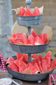 watermelon slices are stacked on top of each other in metal trays for display