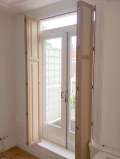 an empty room with a toilet and window