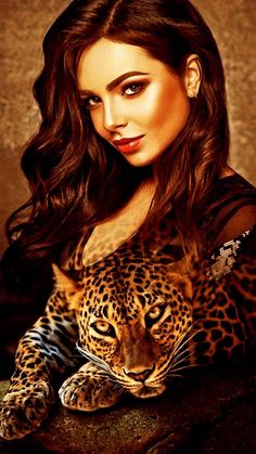 a woman with long hair is holding a large leopard in her arms and posing for the camera