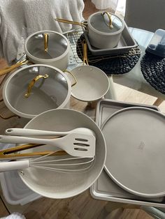 a table topped with dishes and utensils on top of a wooden floor next to a window