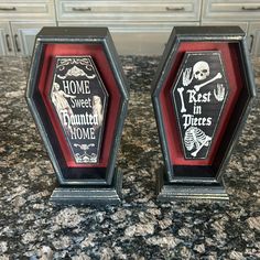 two black and red plaques sitting on top of a granite counter next to each other