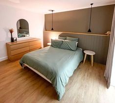 a bed sitting in a bedroom next to a wooden dresser and mirror on top of a hard wood floor