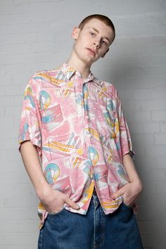 Ready yourselves for this jazzy vintage shirt featuring retro geometric shapes printed all over. This is the kind of geometry we can get behind! Comes in pastel pink to contrast the blue/yellow shape pattern. This is an iconic rare 70s/80s piece that is sure to turn heads. Comes in a relaxed fit and white button down front and collar as well as a nifty front pocket. Near perfect vintage condition- tiny bits of loose threading. No care label but feels like cotton material Width 46" Length 31" XL Casual Pink Tops With Abstract Print, Casual Pink Top With Abstract Print, Retro Patterned Shirt For Summer, Retro Shirt With Colorful Pattern For Summer, Retro Summer Shirt With Colorful Pattern, 90s Inspired Short Sleeve Shirt For Spring, Retro Patterned Printed Shirt, Patterned Retro Print Shirt For Spring, Vintage Summer Shirt With Abstract Print