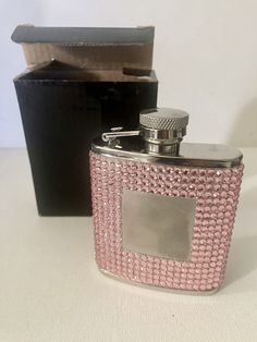 a pink flask with a black box behind it