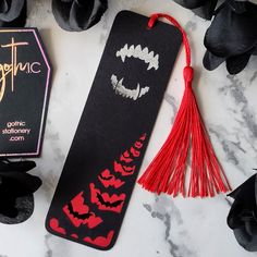 a bookmark with black and red designs on it next to some other items that are laying around