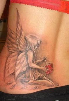 a woman's back with an angel tattoo on her stomach, holding a heart