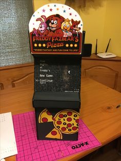 a pizza machine sitting on top of a wooden table next to a piece of paper