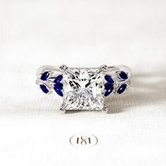 a princess cut diamond ring with blue accents