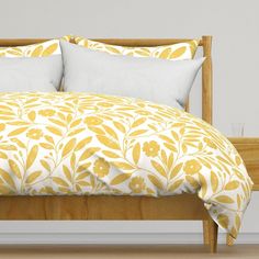 a bed with yellow and white comforters on it