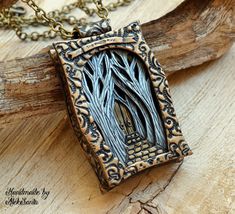 a necklace with a tree in the middle on top of a piece of drift wood