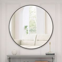 a living room with a white couch and a round mirror