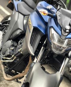 the front end of a blue motorcycle parked in a parking lot