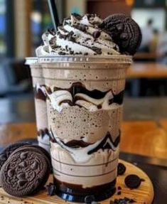 an ice cream sundae with oreo cookies on the side sitting on a table