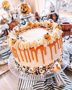 a decorated halloween cake sitting on top of a glass plate with sprinkles