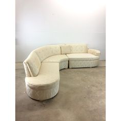 a curved sectional couch in an empty room