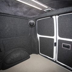 the inside of a vehicle with its door open and some speakers in front of it