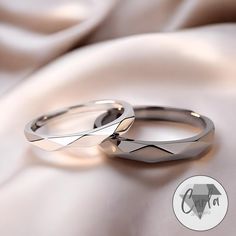 two wedding rings sitting on top of each other