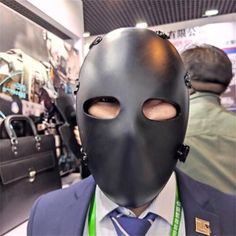 a man in a suit and tie wearing a black mask