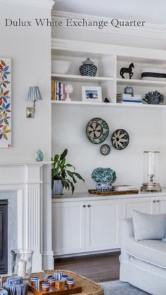 a living room filled with furniture and a fire place in front of a white wall