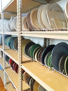 the shelves are filled with many different colored plates