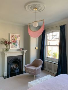 a bedroom with a fireplace, chair and painting on the wall