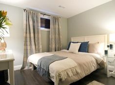 a white bed sitting next to a window in a bedroom