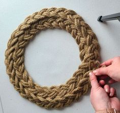 someone is making a rope wreath with scissors