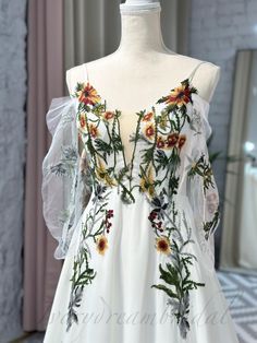 a white dress with flowers and leaves on it