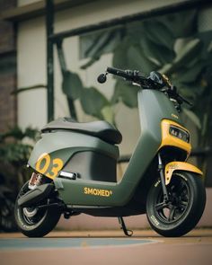 a motor scooter parked in front of a building next to a plant pot