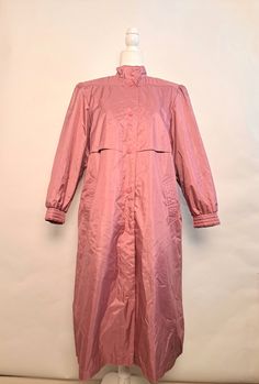 "Vintage Chiango by fleet street 80's pink trench coat.  Amazing coat that will make you want to play in the weather.  Six button snaps for closure.  Button snaps on cuffs, built in shoulder pads, as well as additional lining for extra warmth that can be removed.  Comes with matching waist belt.   Outershell is 100% polyester face, 100% rubber back, lining is nylon, filling is 100% polyester.  Marked size 14, in great vintage condition!   *Please double check measurements to make sure it's a goo Oversized Pink Outerwear With Button Closure, Oversized Pink Outerwear For Daywear, Pink Oversized Outerwear For Daywear, Pink Outerwear For Daywear In Fall, Spring Long-sleeved Raincoat With Button Closure, Spring Long Sleeve Raincoat With Button Closure, Solid Color Raincoat With Button Closure For Spring, Spring Raincoat With Button Closure For Rainy Weather, Pink Raincoat For Fall Rainy Weather