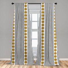 the curtains in this room are decorated with yellow polka dots on black and white stripes