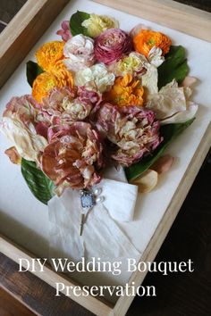 a bouquet of flowers sitting in a wooden box on top of a table with the words diy wedding bouquet presentation