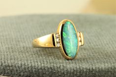 "This is another great Kabana Opal Ring in 18K gold.  Kabana is a US company first noted for their inlaid jewelry.  This ring has a lovely Black Opal stone adorned by bright and well matched Diamond stones. The face of the ring is 5/8\" by 3/8\" and weighs 5.9 in size 5.5. It is fully hallmarked Kabana and is in excellent estate condition." Elegant Gold Rings With Inlay, Oval Opal Ring With Stone Setting For Formal Occasions, Formal Oval Opal Ring With Stone Setting, Elegant Yellow Gold Jewelry With Inlay, Elegant 14k Gold Jewelry With Inlay, Elegant Green Jewelry With Inlay, Elegant Green Rings With Inlay, Elegant Green Inlay Rings, Formal Rings With Inlay