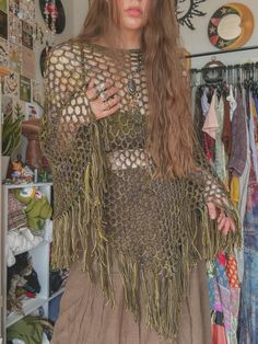 a woman with long hair standing in front of a closet filled with clothes and other items